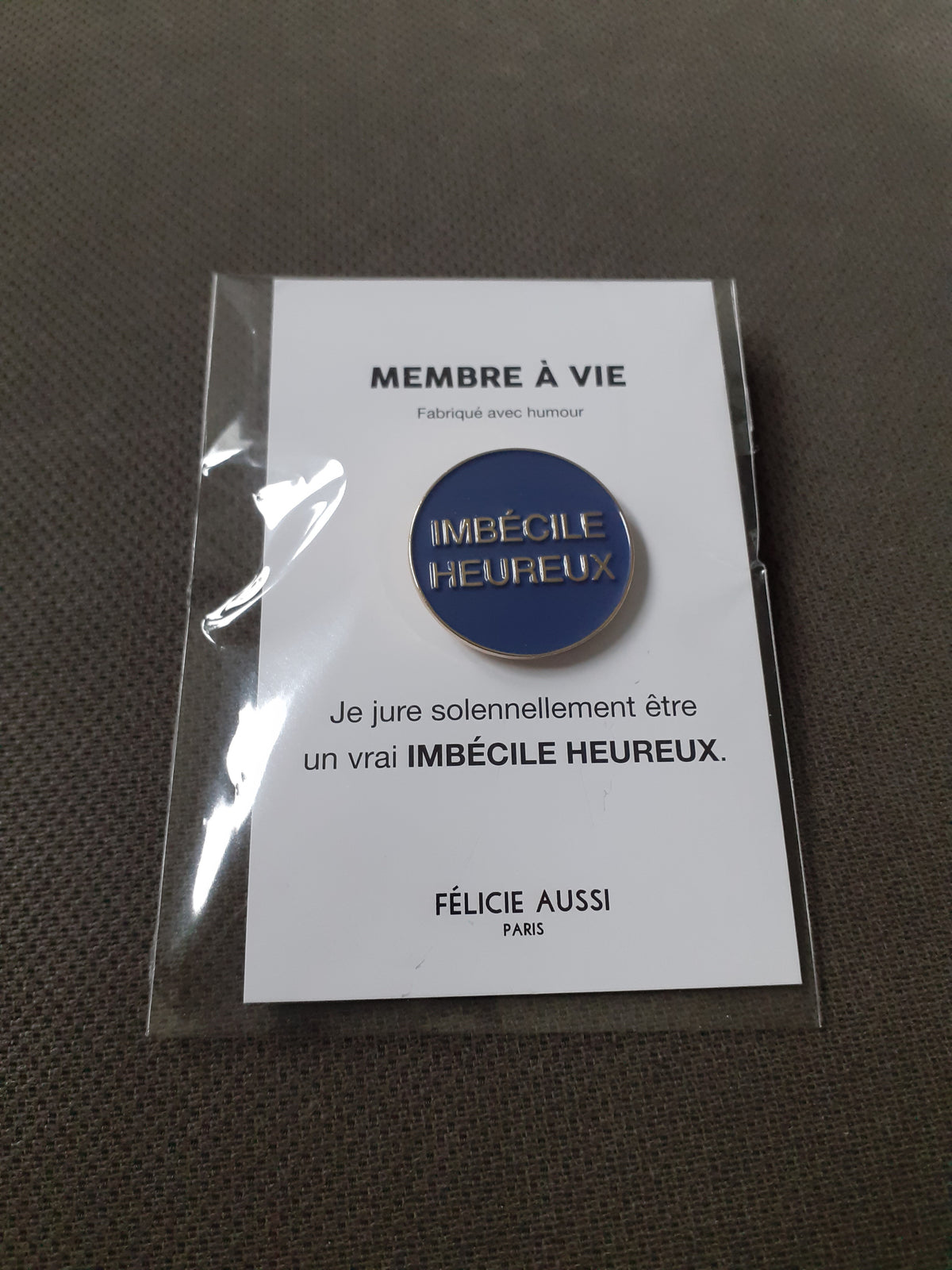 Félicie Aussi - Pin’s – Imbécile Heureux - rond bleu marine
